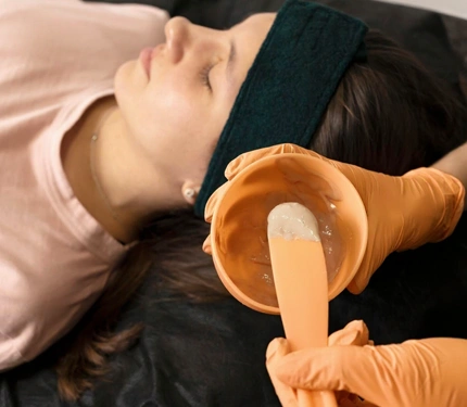 Beautician applying alginate mask female teenage girl face with smooth soft skin