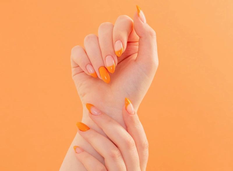 Female hand with manicure orange background